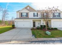 Two-story townhome with attached garage and landscaping at 8127 Paw Club Dr, Charlotte, NC 28214