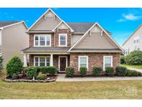 Two-story house with stone and shingle accents, landscaping, and a welcoming front porch at 282 Fischer Rd, Fort Mill, SC 29175