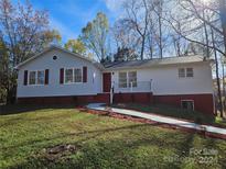 Charming one-story house featuring gray siding and a well-maintained lawn at 7154 Woodcock Trl, Stanley, NC 28164