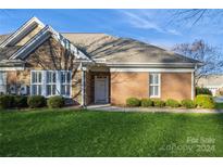 Brick ranch home with stone accents, landscaped lawn, and a spacious driveway at 10934 Casetta Dr, Matthews, NC 28105