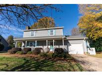 Gray house with teal accents, white porch, and landscaped yard at 702 Pierce Ave, Mount Holly, NC 28120