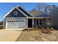 Gray house with white garage door, landscaping, and a two-car garage at 1066 Bull Dog Ln, Wingate, NC 28174