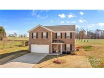 Brick two-story house with a white garage door and landscaping at 109 Vintage Woods Ln, Shelby, NC 28150