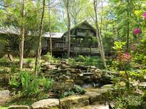 House exterior featuring a large deck and landscaped yard with a stone waterfall at 1202 Brook Dr, Lancaster, SC 29720