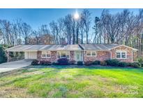 Brick ranch house with attached garage and landscaped lawn at 3143 Whitson Rd, Gastonia, NC 28054