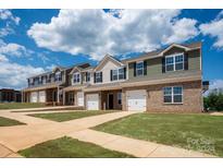 New townhome community with brick and siding exteriors, two-car garages, and landscaped yards at 5156 Tommy Ln # 1301, Stanley, NC 28164
