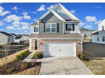 Two-story home with gray and brown siding, white garage door, and landscaping at 109 Watrous Way, Mooresville, NC 28115