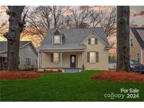 Charming two-story home with a lush green lawn and a welcoming front porch at 415 S Willow St, Gastonia, NC 28034