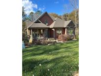 Two-story house with a covered porch and stone accents, situated on a landscaped lawn at 1327 Moonshadow Ln, Shelby, NC 28150