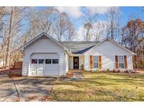 White house with brown shutters, attached garage, and a nicely landscaped lawn at 3711 Sandberry Dr, Waxhaw, NC 28173