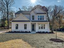 Two-story farmhouse style home with white siding, dark roof, and landscaping at 3837 Bon Rea Dr, Charlotte, NC 28226