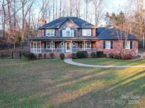 Charming two-story brick home with a covered front porch and landscaped yard at 130 Devine St, Stanley, NC 28164