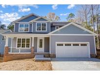 Two-story house with gray siding, white garage door, and a brick porch at 2406 Forrestbrook Dr, Kannapolis, NC 28083