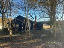 Dark-colored house with a chimney, surrounded by trees and a yard at 3217 Howe Dairy Rd, Gastonia, NC 28056