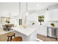 Modern kitchen with white cabinets, quartz countertops, and stainless steel appliances at 9716 Lawing School Rd, Charlotte, NC 28214