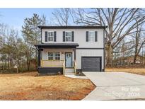 Two-story house with gray siding, black accents, and a light blue front door at 310 Town St, Landis, NC 28088