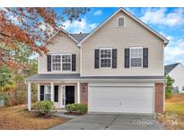 Two-story house with beige vinyl siding, brick accents, and a two-car garage at 808 Plateau Ct, Rock Hill, SC 29730