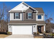 Two-story house with gray and brown siding, white garage door, and landscaping at 15533 Capps Rd, Charlotte, NC 28278