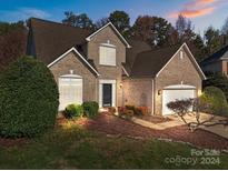 Brick two-story house with attached garage, landscaping, and a welcoming front porch at 16039 Lavenham Rd, Huntersville, NC 28078