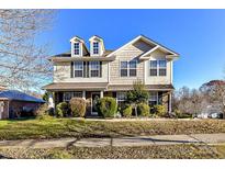 Two-story house with vinyl siding, landscaped lawn, and a two-car garage at 7534 April Mist Trl, Huntersville, NC 28078