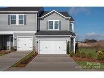 Gray two-story townhome with white garage doors and landscaping at 5025 Kellaher Pl, Charlotte, NC 28216