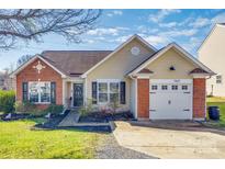 Brick ranch home with a 1-car garage and landscaped lawn at 11621 Clear Day Ct, Charlotte, NC 28269