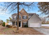 Two-story house with stone and gray siding, attached garage, and landscaping at 1805 Lexington Ave, Monroe, NC 28112