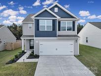 Two-story house with gray and blue siding, two-car garage, and landscaped lawn at 654 Lancelot Dr, Richburg, SC 29729