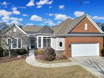 Brick ranch home with stone accents, a large garage, and landscaping at 10474 Bethpage Dr, Fort Mill, SC 29707