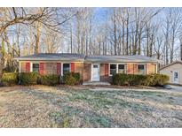 Brick ranch house with red shutters, landscaping, and a front yard at 1203 Northwoods Dr, Kings Mountain, NC 28086