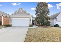 Gray siding ranch home with white garage door and landscaping at 15331 Legend Oaks Ct, Fort Mill, SC 29707