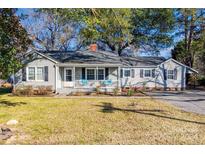 Charming ranch home with a covered front porch and well-maintained lawn at 708 N Main St, Lowell, NC 28098