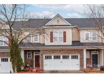 Tan and stone three-story townhome with two-car garage at 6725 Dusty Saddle Rd, Charlotte, NC 28277