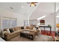 Spacious living room with vaulted ceilings, a cozy fireplace, and hardwood floors at 10113 Allison Taylor Ct, Cornelius, NC 28031