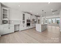 Modern kitchen with island, stainless steel appliances, and ample cabinet space at 711 Hoke Ln, Davidson, NC 28036
