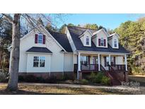 Charming two-story home with a front porch, large windows, and a welcoming facade at 8046 Lucky Creek Ln, Denver, NC 28037