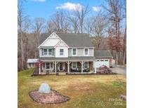 Two-story house with a wraparound porch and landscaped yard at 10827 Hadrians Walk Ct, Mint Hill, NC 28227