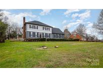 Two-story house with gray siding, multiple windows, and a landscaped lawn at 8823 Dartmoor Pl, Mint Hill, NC 28227