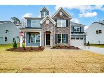 Two-story home with stone and siding, attached garage, and landscaped lawn at 2011 Cedar Falls Dr # 71, Waxhaw, NC 28173