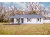 Charming white house with a spacious yard and covered porch at 364 Scotts Creek Rd, Statesville, NC 28625