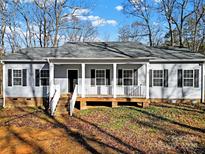 Gray house with white trim, front porch, and black shutters at 10225 Nugget Place Rd, Midland, NC 28107