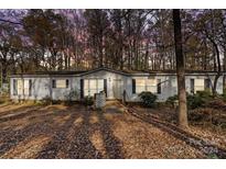 Single-wide mobile home exterior with wooded backdrop at 12813 Peppercorn Ln, Midland, NC 28107