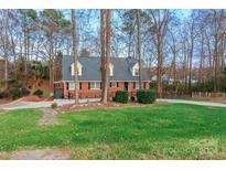 Brick ranch house with gray roof, landscaped yard, and long driveway at 2276 Wintercrest Dr, Rock Hill, SC 29732