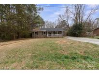 Ranch style home with brick facade and a spacious front yard at 1975 W Wall St, Wadesboro, NC 28170