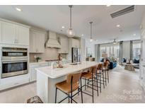 Open concept kitchen with island, stainless steel appliances, and white cabinetry at 5015 Westmead Ln, Charlotte, NC 28262