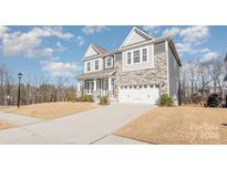 Charming two-story home with a stone and siding exterior, front yard landscaping, and attached garage at 3013 Haley Cir, Davidson, NC 28036