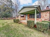 Brick ranch house with covered porch, landscaping, and a spacious yard at 313 Lake Montonia Rd, Kings Mountain, NC 28086
