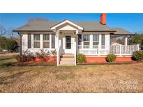 Charming white house with red brick base, front porch, and landscaping at 4385 Nc Hwy 73 E Hwy, Concord, NC 28025