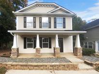 Two-story house with beige siding, stone accents, and a front porch at 4438 Cochran Farm Ln, Charlotte, NC 28269