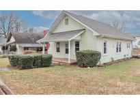 Charming light yellow home with a small front porch and landscaped yard at 621 Spruce St, Mooresville, NC 28115